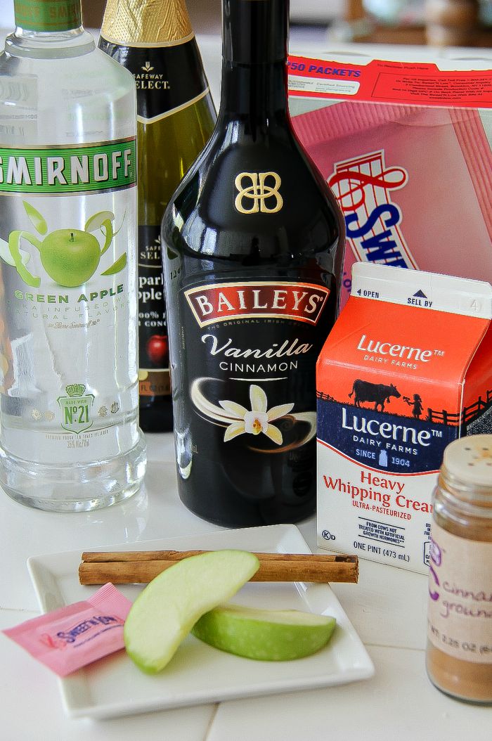 Baileys, apple vodka, cream, and cinnamon stick to make a cocktail