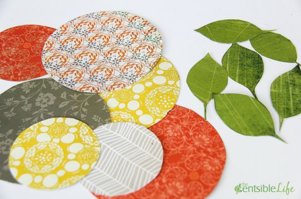 assorted sizes and colors of paper circles cut out in fall colors to make flowers