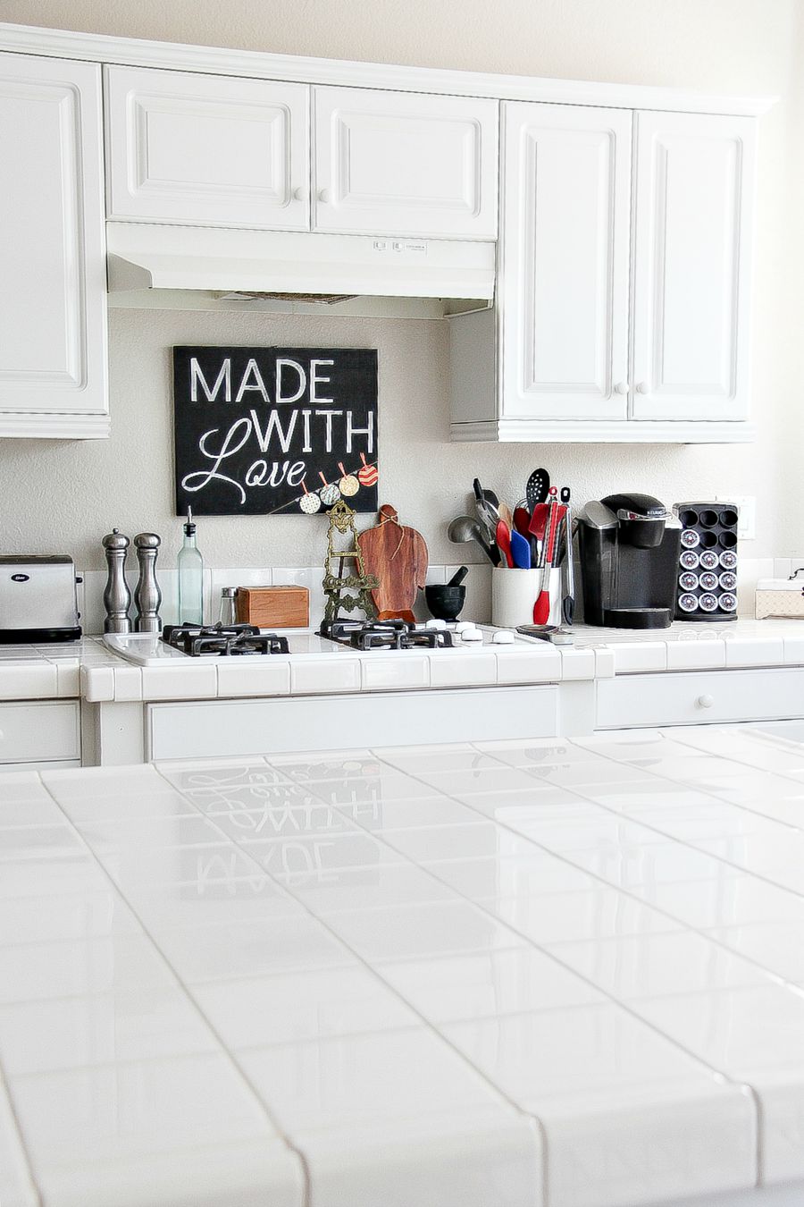 white kitchen with tiles and a made with love sign