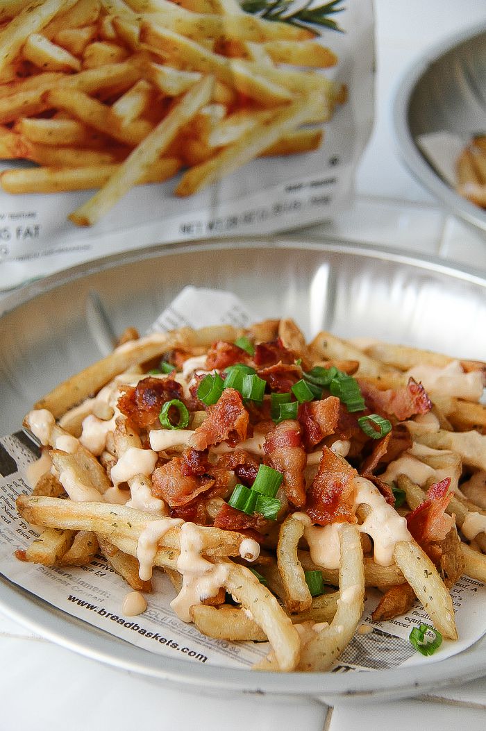 french fries topped with bacon, sauce, and green onions
