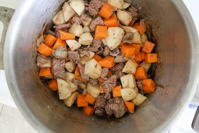 stainless steel stock pot with beef and butternut squash stew cooking