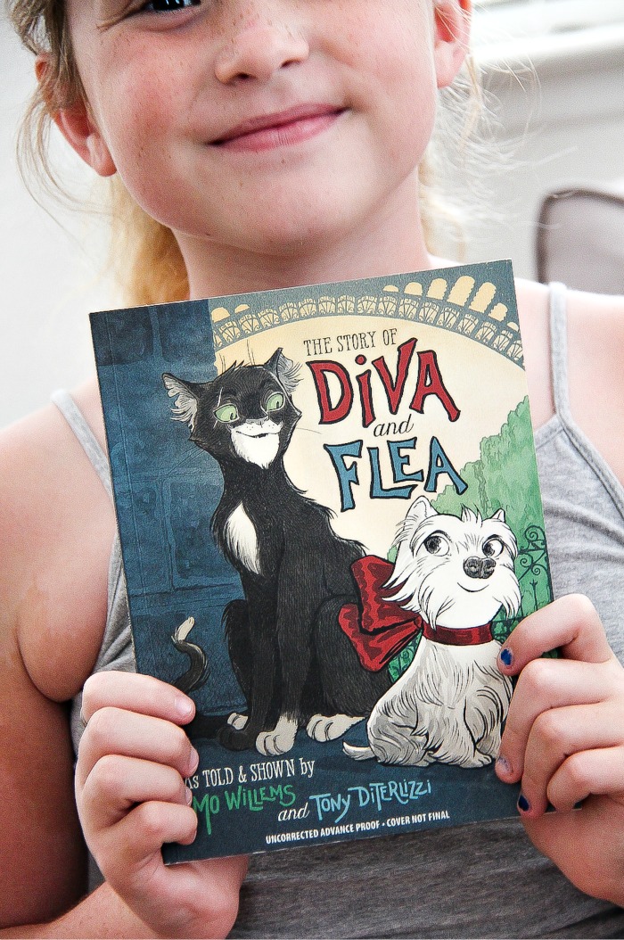 girl holding the book Diva and the Flea