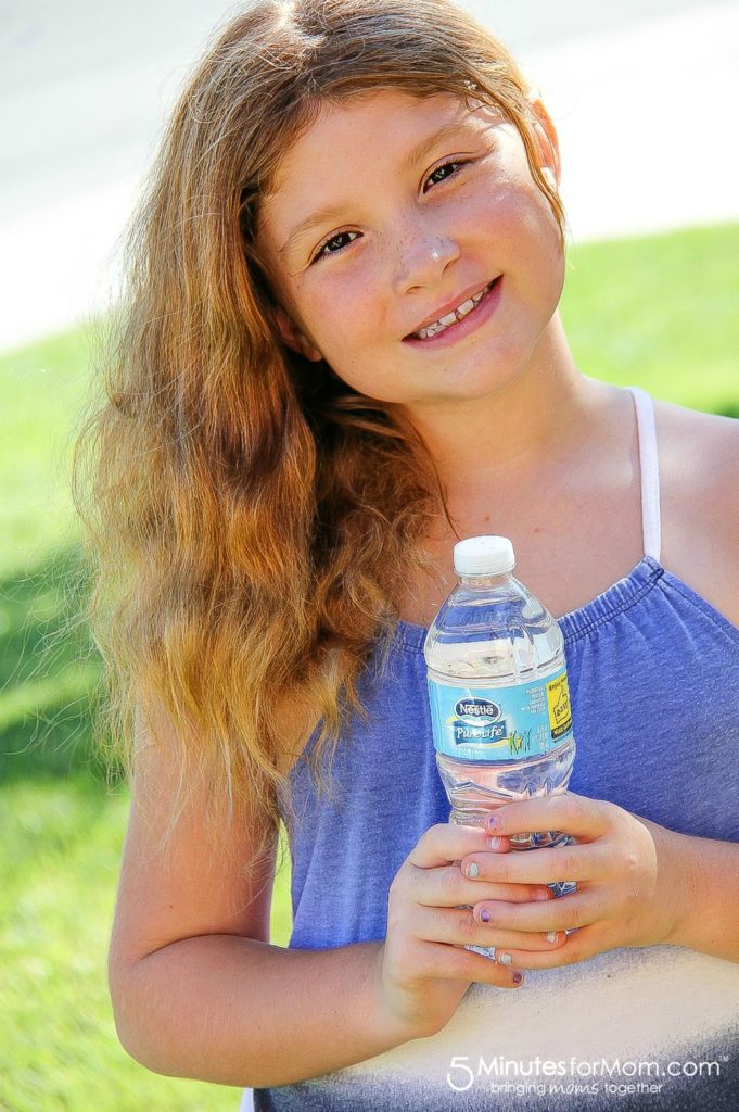 girl holding a nestle pure life water bottle