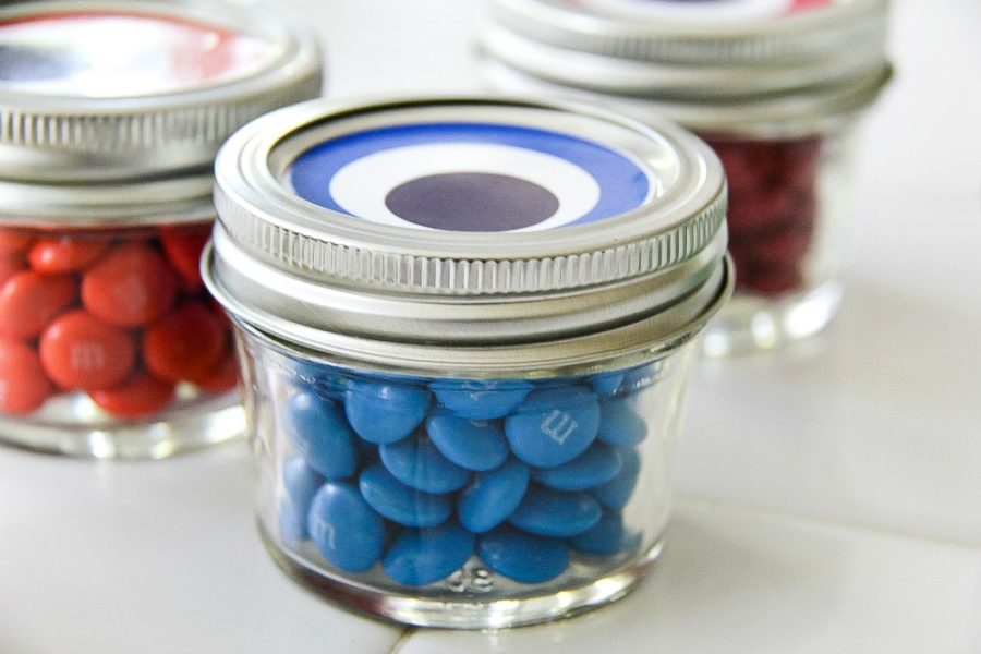 canning jar filled with blue candy with an eye on top of it