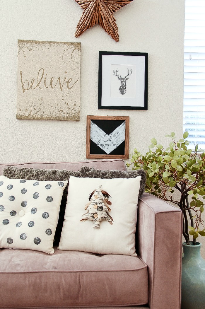 black and white cushions on a couch with black and white holiday decor on the wall behind it
