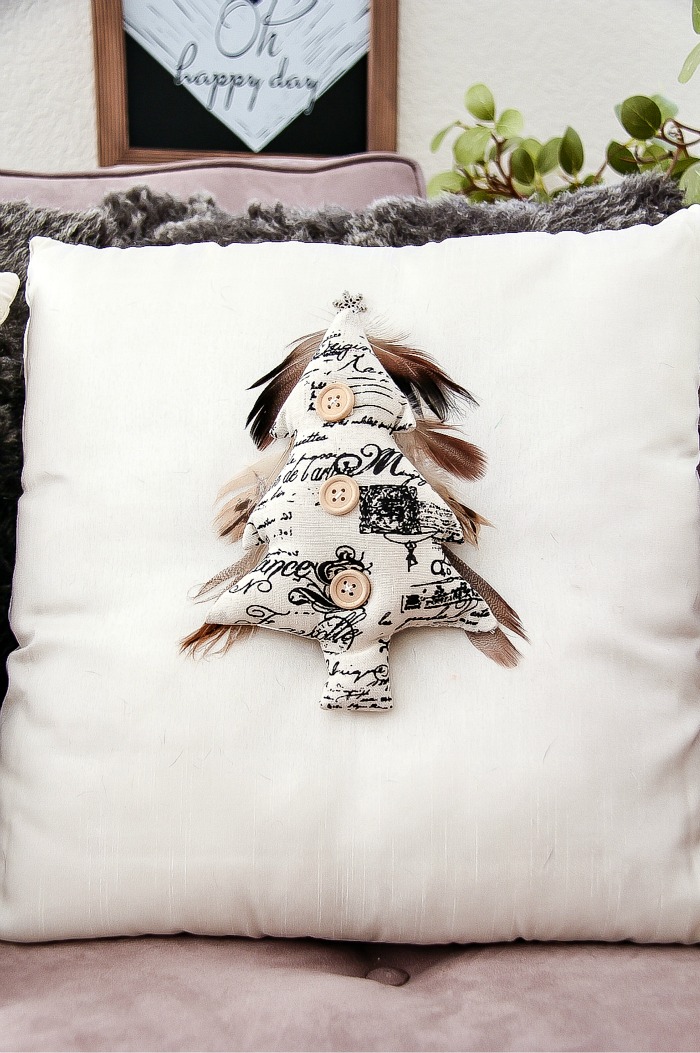 fabric christmas tree with feathers on a cushion