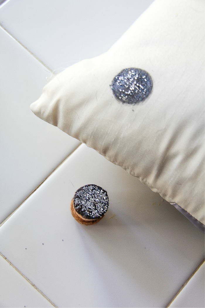 a glitter dot painted on a cushion using a cork