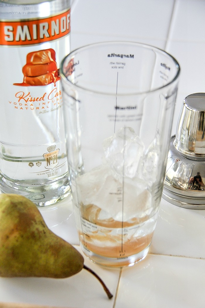 a cocktail shaker with Smirnoff Kissed Caramel vodka and caramel syrup to make a fall drink