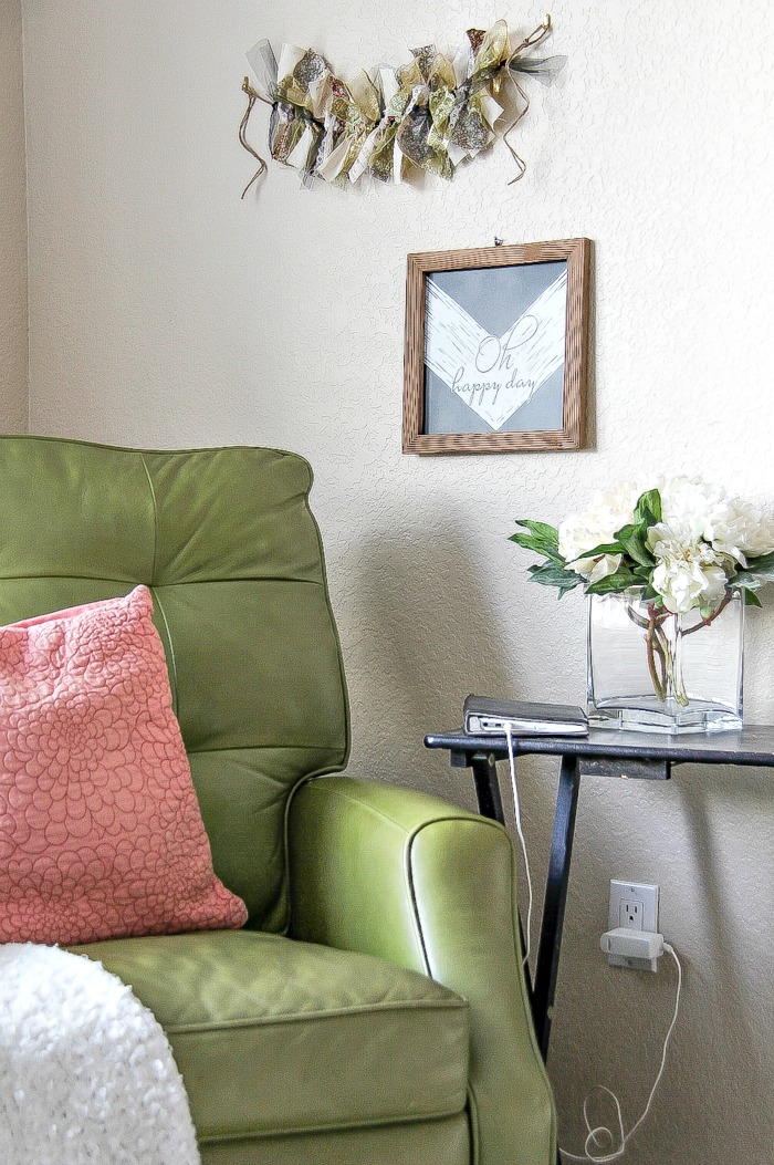 green recliner with side table and wall art