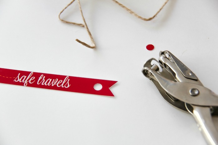 red and white safe travels gift tag with hole punch