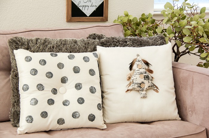 black, silver, tan, and white christmas cushions on a couch