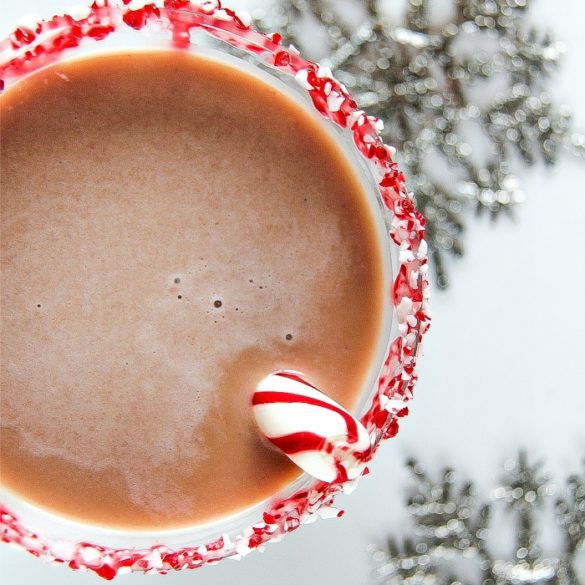 looking down on a peppermint bark martini in a glass with a peppermint stick