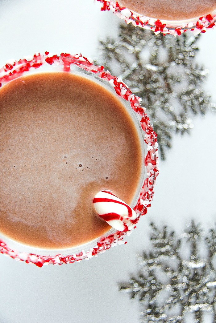looking down on a peppermint bark martini in a glass with a peppermint stick