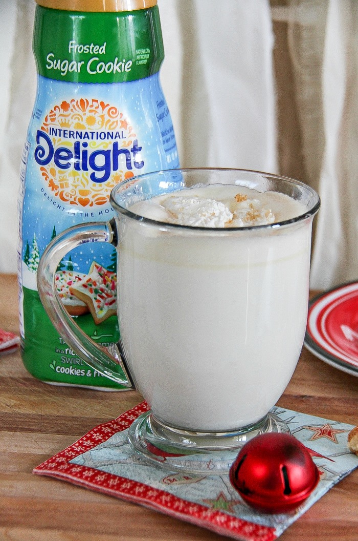 white hot chocolate in a glass with international delight sugar cookie creamer in the background