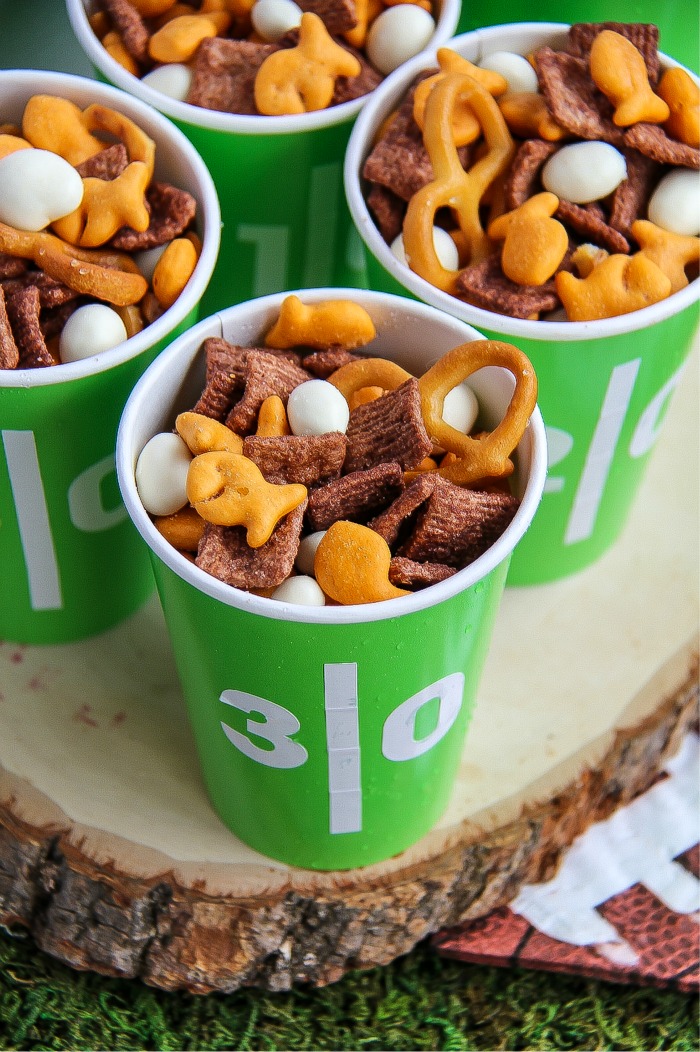 goldfish, pretzels and other snacks in football themed green and white cups