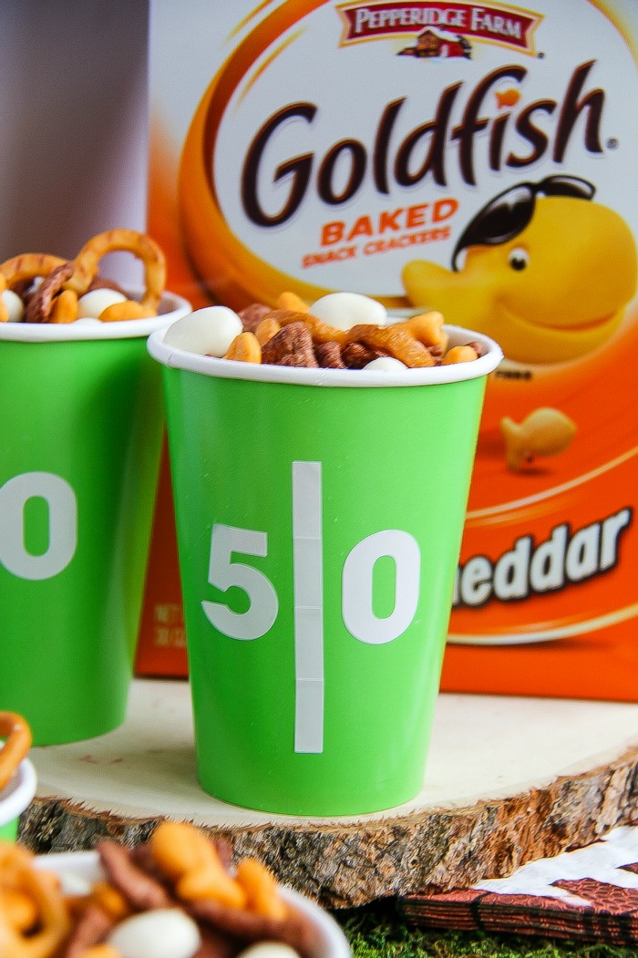 green and white football themed cups filled with snacks with a box of Goldfish crackers in the background