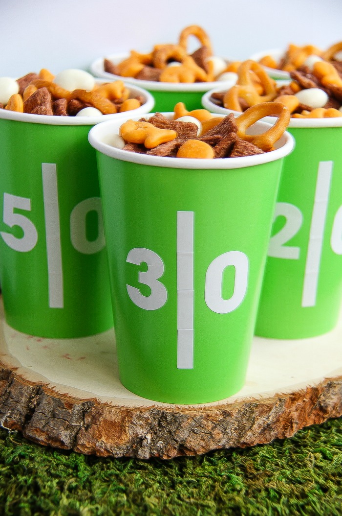 green and white football yard line cups filled with snack mix