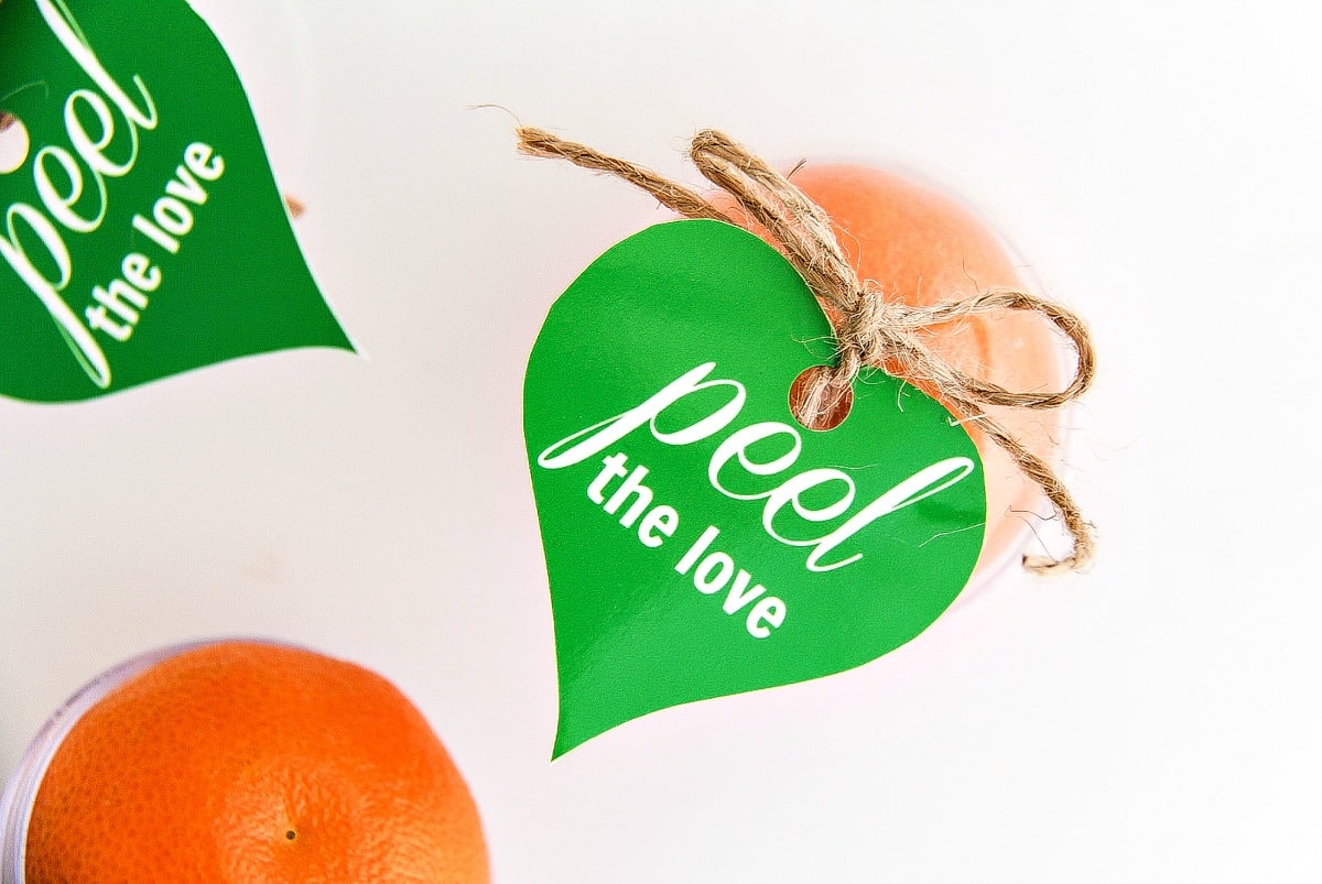 a peel the love gift tag attached to a mandarin orange