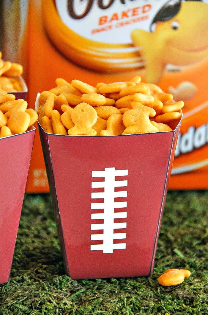 yellow goldfish crackers in a football paper cup with a box of goldfish in the background