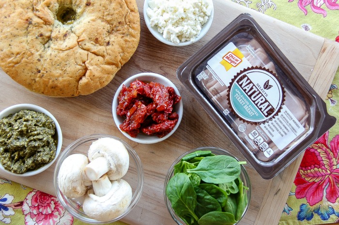 sundried tomatoes, spinach, mushrooms, and turkey on a board