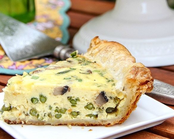 a slice of asparagus and mushroom quiche on a white plate