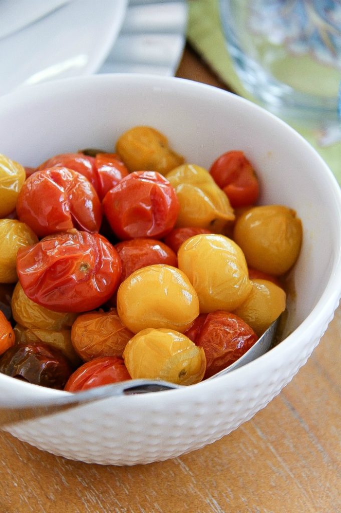 a white bowl filled with yellow and red mini heirloom tomatoes