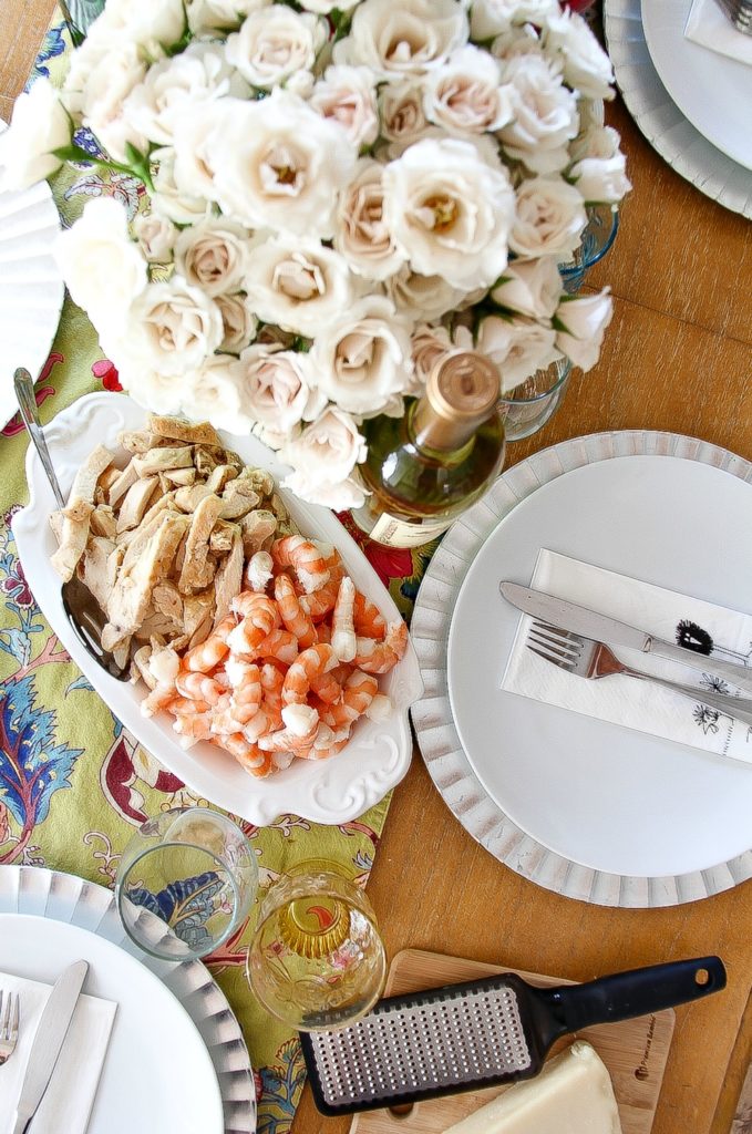 looking down over fresh flowers by a serving tray with chicken and shrimp