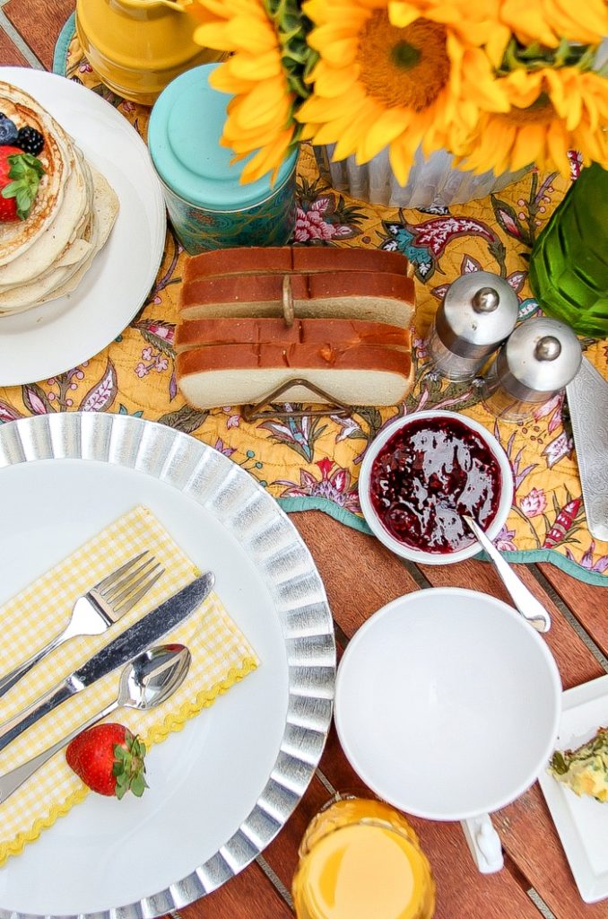 looking down over a styled brunch table set with plates, jam, and toast