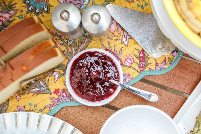 raspberry jam and fresh bread on a table for brunch