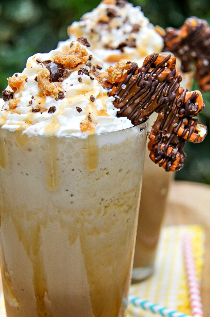 iced caramel macchiato topped with chopped coffee beans, caramel, and whipped cream