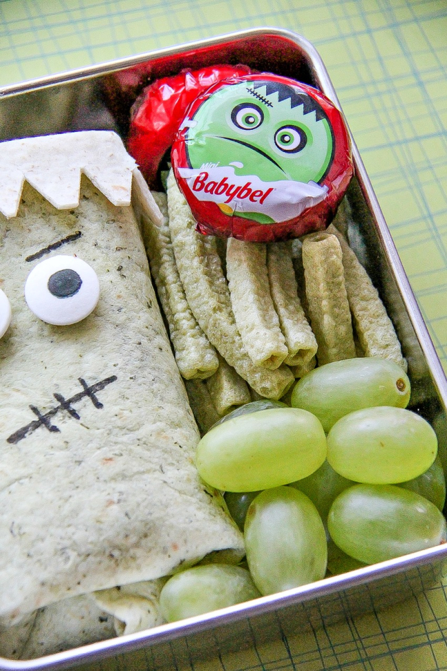 Frankenstein Friday Halloween treats for kids including a sandwich wrap and fruit.