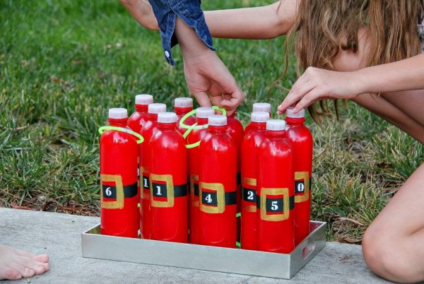 kids playing a handmade santa ring toss game with plastic bottles