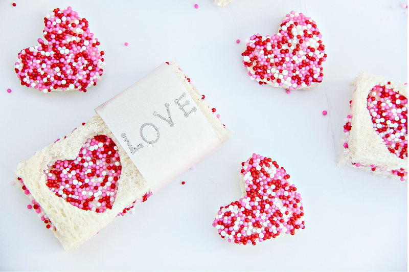 Miniature heart-shaped fairy bread and fairy bread sandwiches for Valentine's Day.