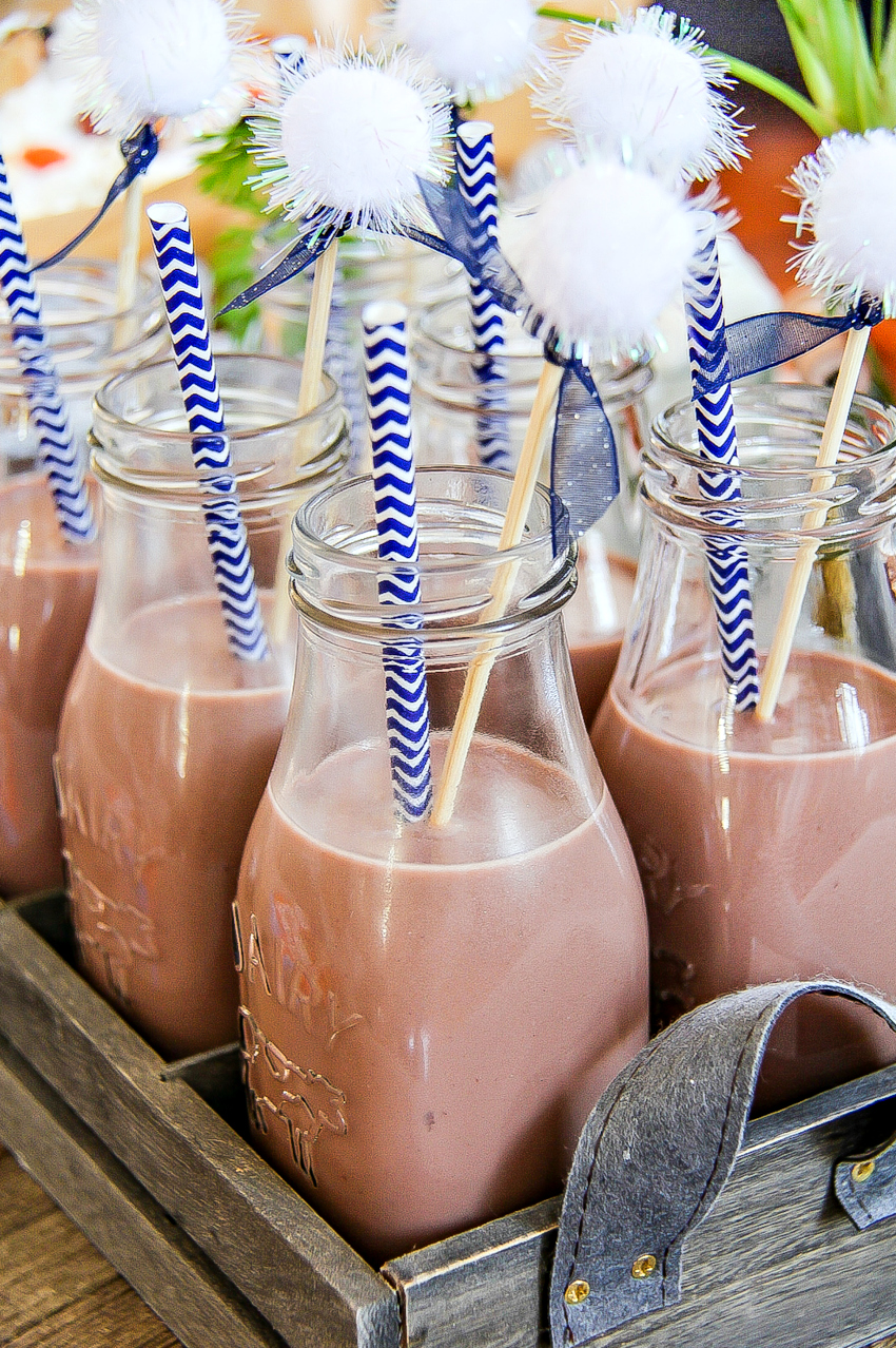 Bottles of chocolate milk with paper straws and bunny tail drink stirring sticks inside.