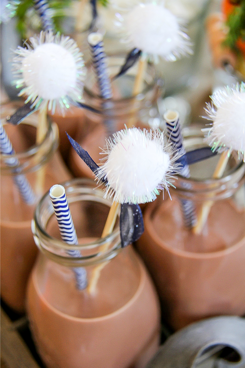 chocolate milk in drink bottles with blue and white striped paper straws and diy cotton tail drink stirrers