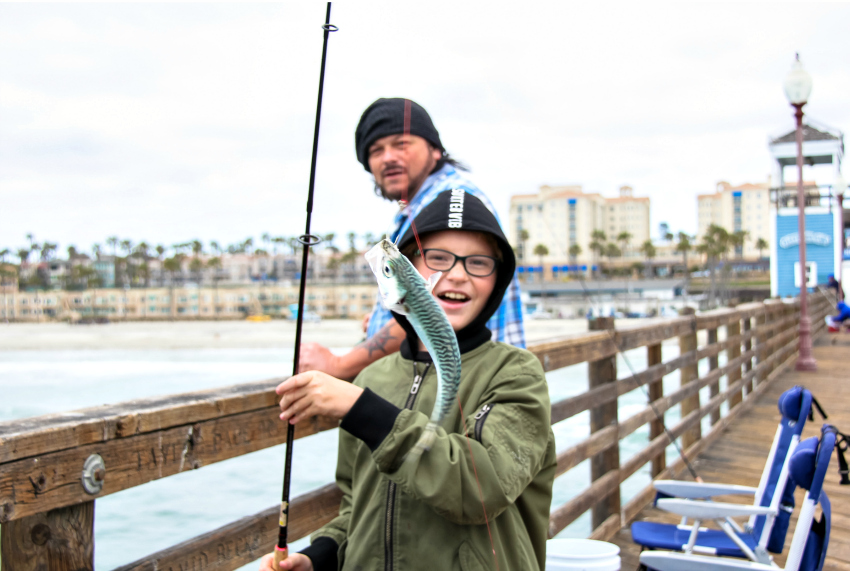 a boy catching a fish at Oceanside Pier in Southern California
