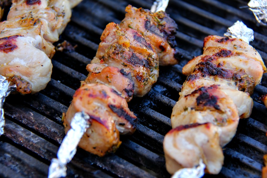 Pork kebabs being cooked on an outdoor grill.