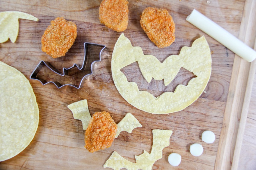 Bat wings being made out of tortillas for Halloween party food.