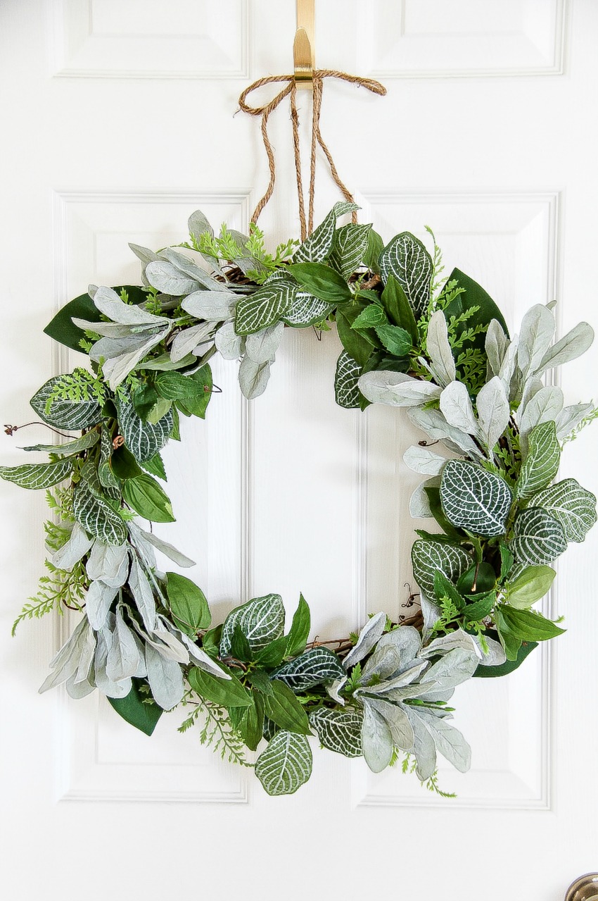 A simple round door wreath made with greenery and a stick circle