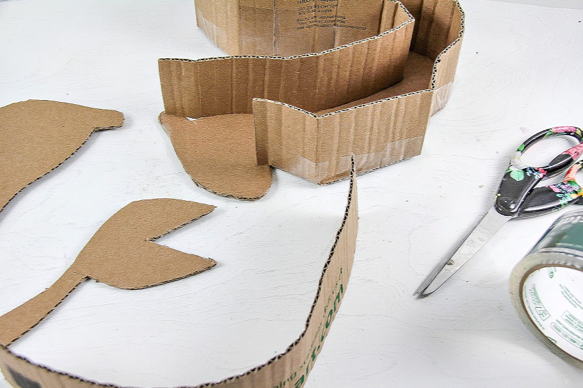 A DIY pull-string pinata being made out of a cardboard box.