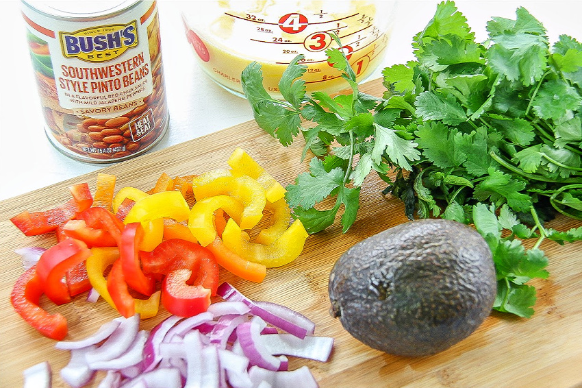 Fresh peppers, onion, avocado, and cilantro to use in a breakfast bowl recipe.