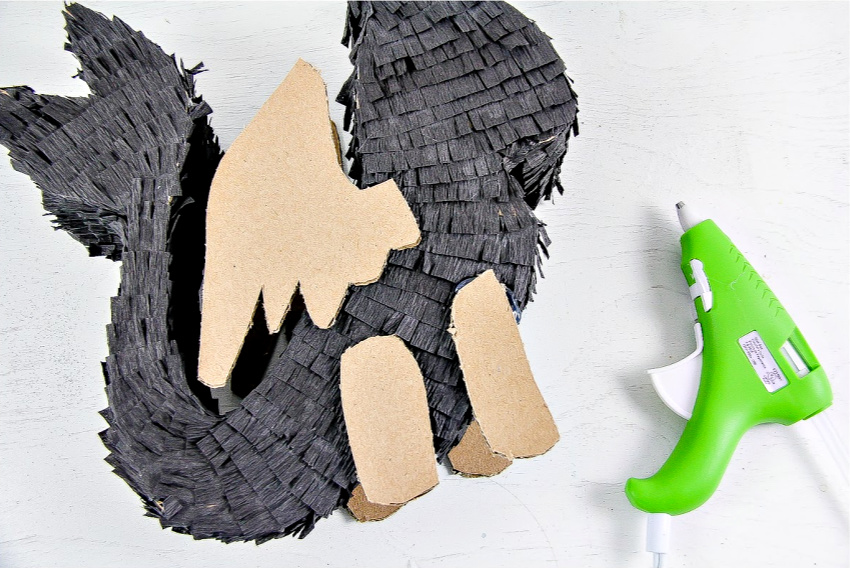 A black DIY pull-string dragon pinata being made.