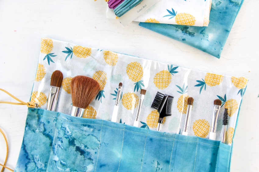 a handmade makeup brush roll in pineapple and blue fabric