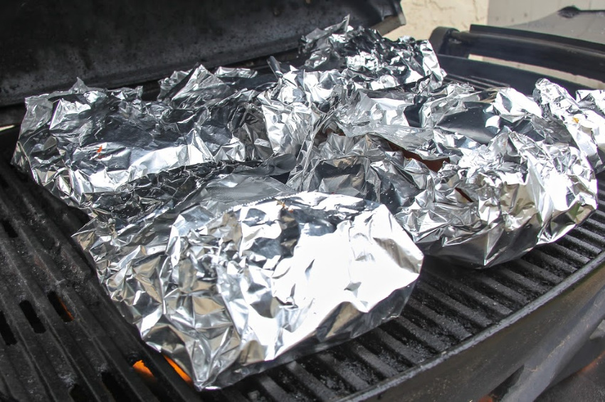 Salmon foil packets being cooked on the grill.