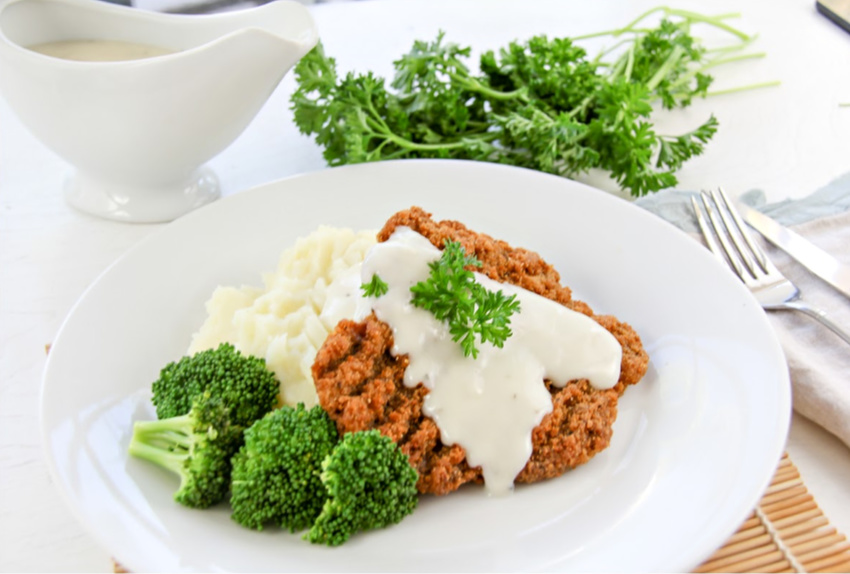 country fried steak with broccoli, mashed potatoes and gravy.