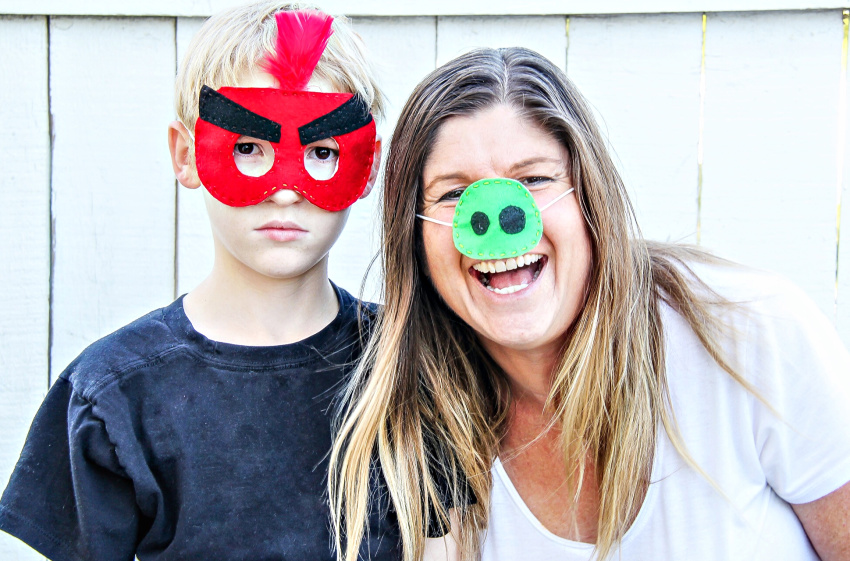 A mother and son wearing handmade angry birds face masks.