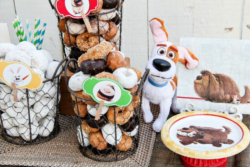 Baskets of donuts, candy, and Secret Life of Pets tableware for a movie night with kids. 