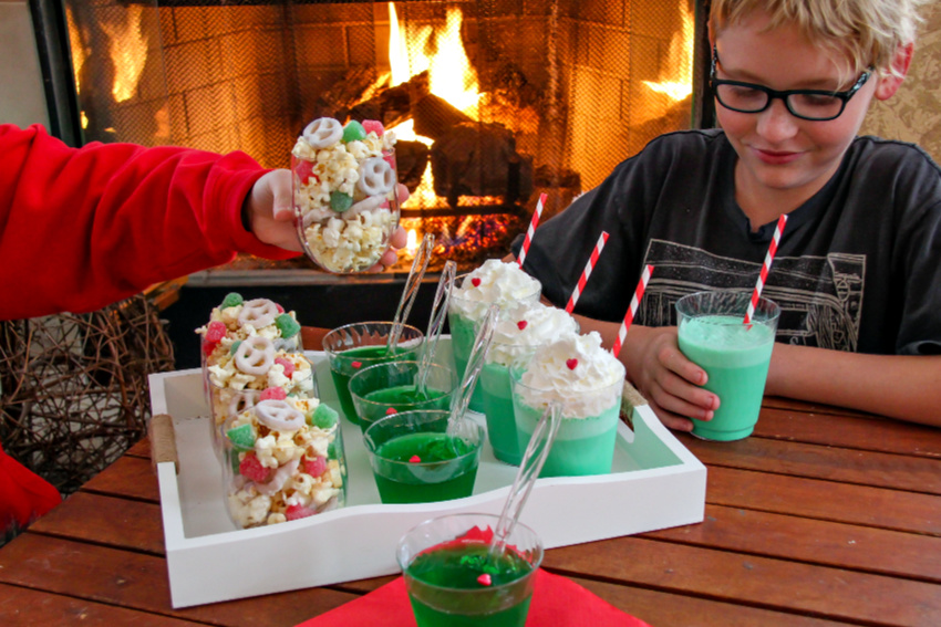 kids enjoying red, green, and white food in front of a fire