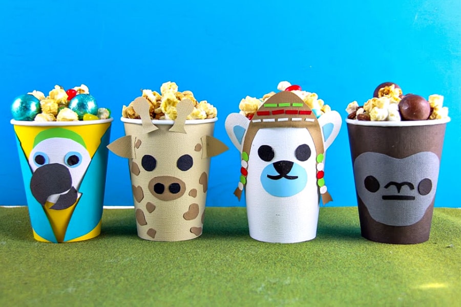 Handmade Dolittle snack tubs using paper cups and filled with popcorn and movie night snacks.