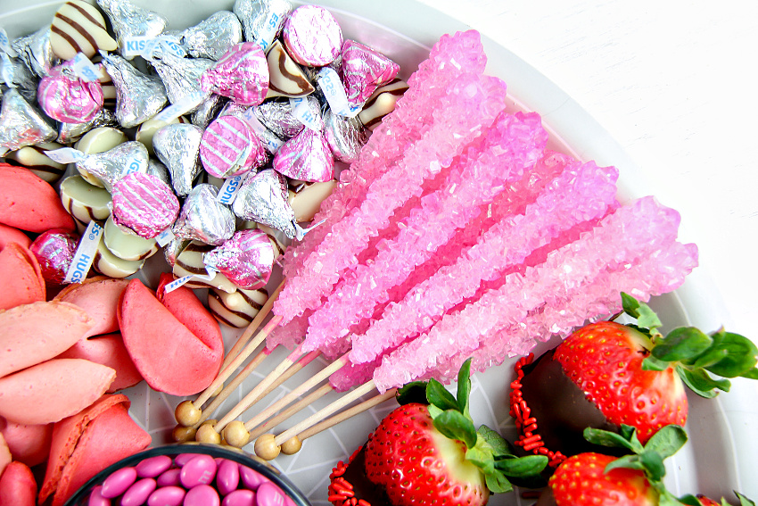 rock candy lollipops and hershey's kisses with chocolate covered strawberries and pink fortune cookies